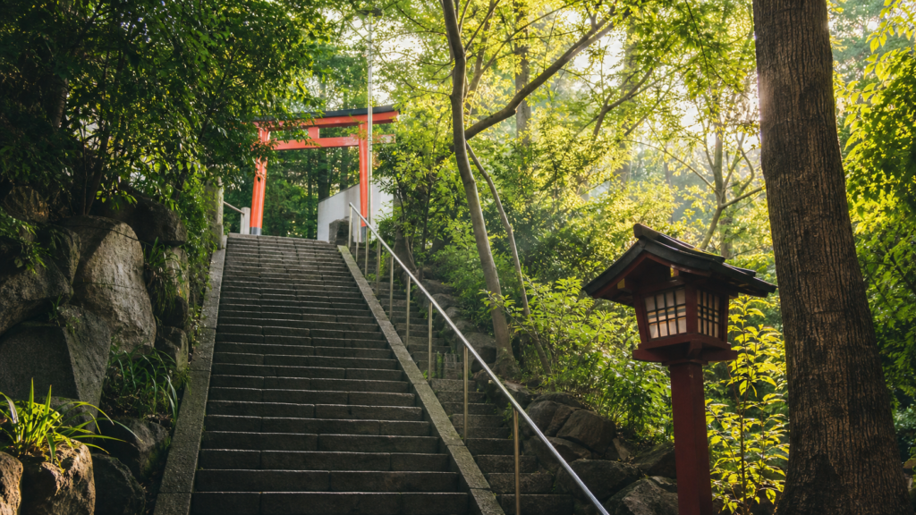 木立の中を伸びる急な石段と朱色の鳥居を描いた、都心の神社参拝のオリジナルイメージ